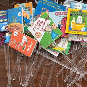 Pu&ograve; includere: Una collezione di repliche in miniatura di libri per bambini fissate su bastoncini di plastica trasparente. L'assortimento include titoli come Green Eggs and Ham, If You Give a Mouse a Cookie, James and the Giant Peach e Bunny Cakes, caratterizzati da copertine illustrate a colori.