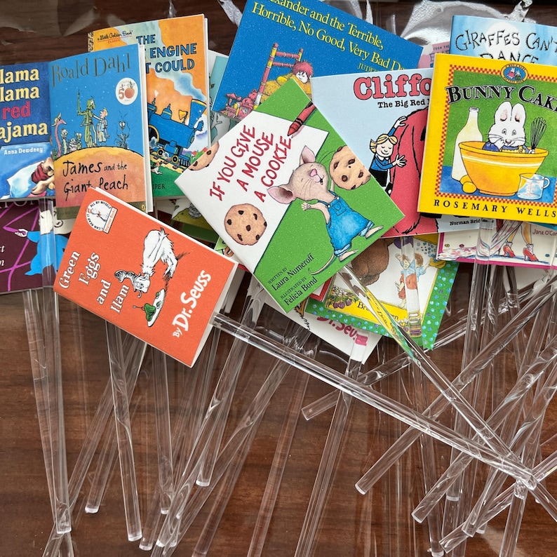 Pu&ograve; includere: Una collezione di repliche in miniatura di libri per bambini fissate su bastoncini di plastica trasparente. L'assortimento include titoli come Green Eggs and Ham, If You Give a Mouse a Cookie, James and the Giant Peach e Bunny Cakes, caratterizzati da copertine illustrate a colori.