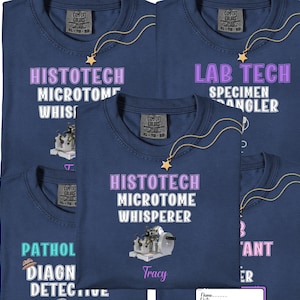 May include: Navy blue t-shirts with various medical lab technician-themed designs. One shirt reads "HISTOTECH MICROTOME WHISPERER" with a microscope graphic. Another says "LAB TECH SPECIMEN ANGLER". Each shirt has a gold star necklace.