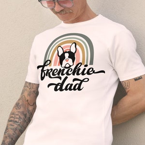 A gay French Bulldog dog dad tshirt - the perfect gift for him! This tee features a Pride rainbow and a French bull dog graphic with the words Frenchie dad in decorative writing. Celebrate the gay man in your life and the bond between him and his dog