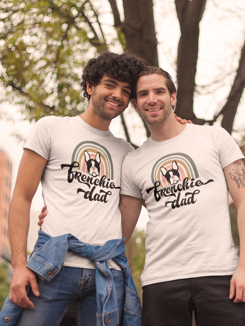 A gay French Bulldog dog dad tshirt - the perfect gift for him! This tee features a Pride rainbow and a French bull dog graphic with the words Frenchie dad in decorative writing. Celebrate the gay man in your life and the bond between him and his dog