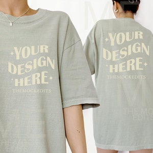 Op de afbeelding: Een lichtgroen T-shirt met de tekst "YOUR DESIGN HERE" en "THEMOCKEDITS" bedrukt op de voor- en achterkant.