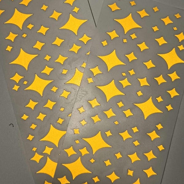 Könnte beinhalten: Zwei Blätter aus klarem Kunststoff mit einem sich wiederholenden Muster aus gelben Diamanten.