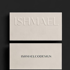 Puede incluir: Dos tarjetas de visita color crema. La tarjeta superior tiene el nombre "ISHMAEL" en relieve en mayúsculas. La tarjeta inferior tiene el texto "ISHMAELCODESIGN" impreso en una fuente sencilla. El fondo es gris oscuro.