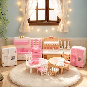 May include: A miniature dollhouse kitchen set featuring two refrigerators, two kitchen counters with sinks and utensils, two dining tables with chairs, and small cookware. The set is arranged on a round white rug in a room with a window.