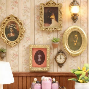 May include: A collection of miniature gold-framed portraits and a clock adorn a floral wallpapered wall. The frames vary in shape, including oval and rectangular, and feature vintage-style images. A small wall-mounted lamp and potted plants add to the decorative arrangement.