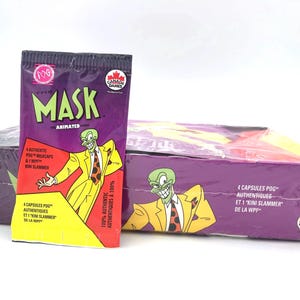 May include: Sealed boxes and packs of "The Mask: Animated Series" POGs. The packaging is purple, yellow, and green, featuring the character in a yellow suit and green face. The boxes and packs are wrapped in clear plastic.