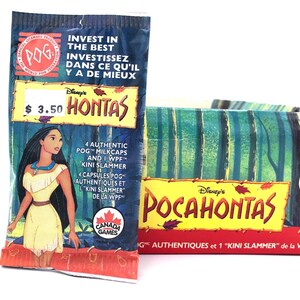 May include: A Disney Pocahontas POG game set featuring a vertical blue foil wrapper with an illustration of Pocahontas and a matching rectangular box. Both items display the Canada Games logo, the text Pocahontas, and indicate they contain 4 milkcaps and 1 Kini slammer.