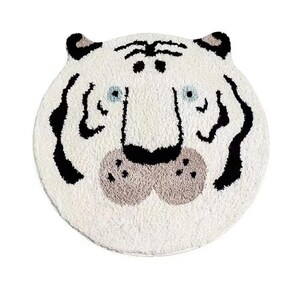 May include: White plush rug featuring a black and white tiger face design. The tiger has a black nose and brown whiskers.