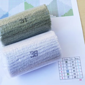 May include: Two rolls of embroidery floss, one green and one white, with the numbers 31 and 38 printed on them. A chart with the numbers 31, 37, 38, 40, 45, and 56 is visible in the background.
