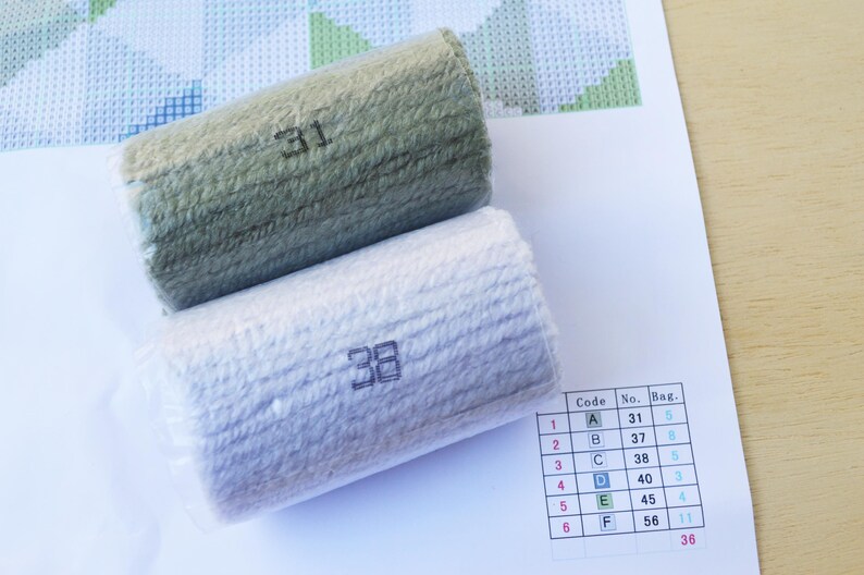 May include: Two rolls of embroidery floss, one green and one white, with the numbers 31 and 38 printed on them. A chart with the numbers 31, 37, 38, 40, 45, and 56 is visible in the background.