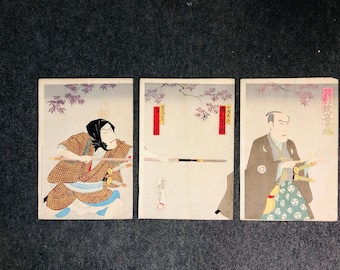 May include: Three Japanese woodblock prints featuring figures in traditional attire. The prints depict scenes with swords, branches, and text. The color palette includes shades of brown, red, and white, with a light purple background.