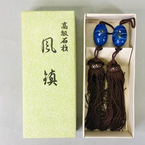 May include: A pair of blue and white glass tassel ornaments with brown tassels in a box. The box has Japanese text that reads "High-grade Nameplate Wind Fish".