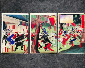 May include: A three-panel woodblock print depicting a battle scene with samurai warriors in red, blue, and black clothing. The print is set against a backdrop of trees and buildings. The print is in the ukiyo-e style, a traditional Japanese art form.
