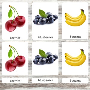 Peut inclure: Un ensemble de six cartes m&eacute;moire illustrant des cerises, des myrtilles et des bananes. Chaque carte a un fond blanc et le nom du fruit est imprim&eacute; en noir en bas.