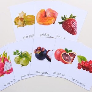 Peut inclure: Un ensemble de cartes m&eacute;moire repr&eacute;sentant diff&eacute;rents fruits, dont la carambole, la figue de Barbarie, la fraise, le fruit du dragon, la groseille &agrave; maquereau, le mangoustan, l'orange sanguine et les groseilles rouges. Chaque carte pr&eacute;sente une image du fruit et le nom du fruit &eacute;crit en dessous.