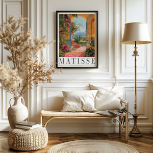 May include: A vintage poster featuring a painting by Henri Matisse. The poster depicts a colorful scene of a doorway opening to a view of a blue sea and sky. The text "MATISSE" is printed in bold letters at the bottom of the poster.