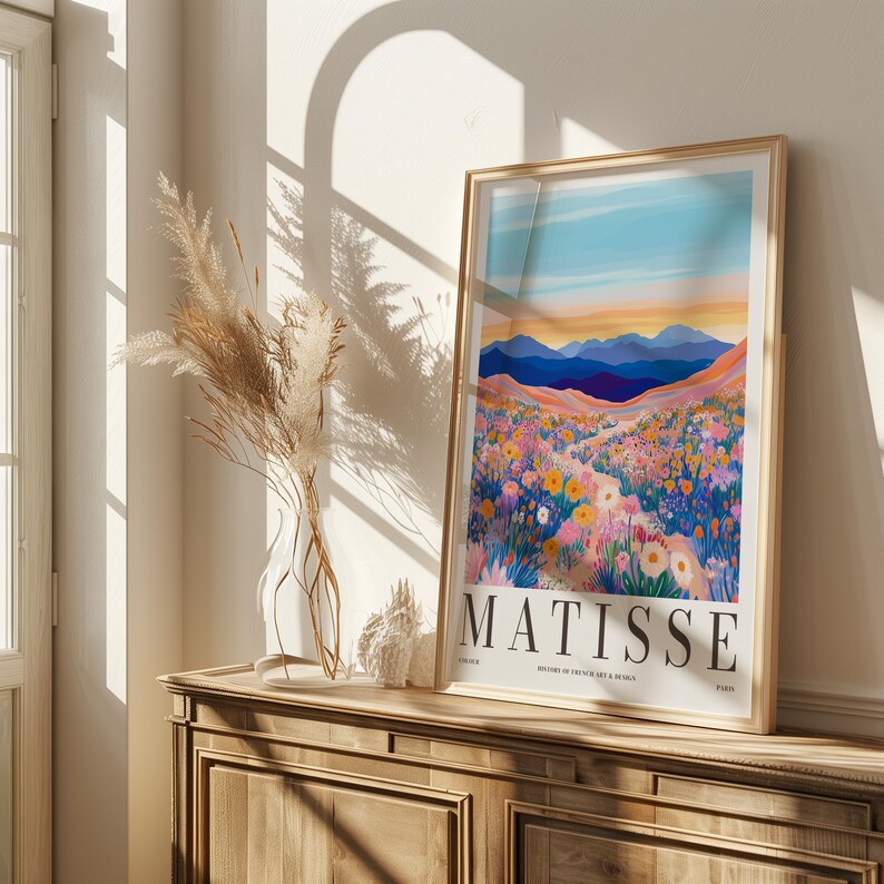 May include: A framed print of a colorful landscape painting with a field of flowers and mountains in the background. The print is titled "Matisse" and features a blue sky with a sunset.