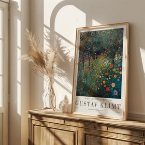May include: A framed poster featuring a painting by Gustav Klimt. The painting depicts a colorful landscape with trees and flowers. The poster is titled "20th Century Exhibition" and features the artist's name, "Gustav Klimt", in large, bold letters.