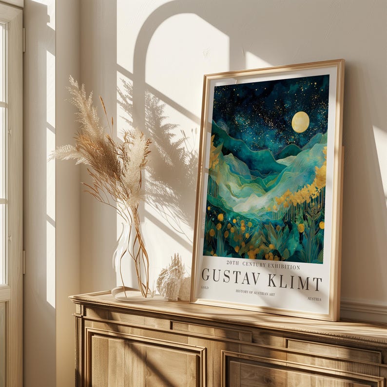May include: A framed art print featuring a landscape painting with a night sky, mountains, and yellow flowers. The print is labeled "GUSTAV KLIMT" and "20TH CENTURY EXHIBITION". The frame is gold-colored, and the artwork is displayed on a wooden cabinet.