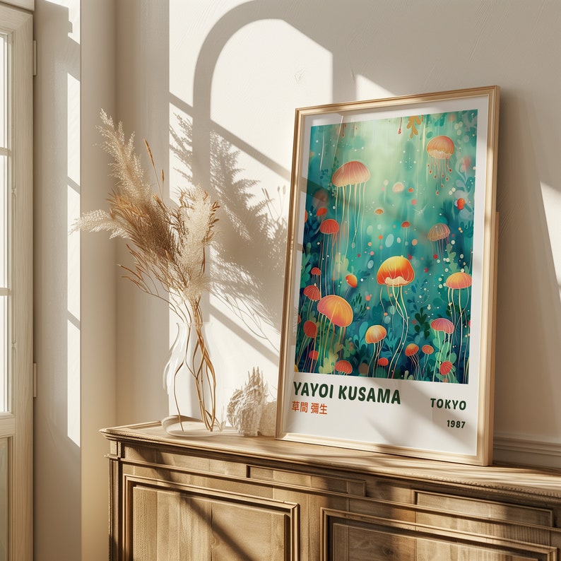 K&ouml;nnte beinhalten: Ein gerahmtes Poster mit einer farbenfrohen Illustration von Quallen in einem t&uuml;rkisfarbenen und gr&uuml;nen Ozean. Das Poster tr&auml;gt den Titel "Yayoi Kusama" mit dem Text "Tokyo 1987" in der rechten unteren Ecke.