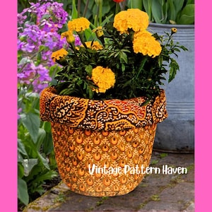 Peut inclure: Un pot de fleurs décoratif avec une housse en tissu à motifs, rempli de fleurs de souci jaunes vibrantes. Le pot présente un motif cachemire marron et orange. Le texte "Vintage Pattern Haven" est visible.