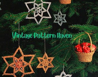 May include: A collection of handmade star-shaped Christmas ornaments in gold and silver, hanging from a Christmas tree. The ornaments are crocheted with intricate details. The image also includes small woven baskets filled with flowers and red berries. Text on the image reads "Vintage Pattern Haven".