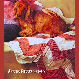 May include: A red and white knitted blanket with a chevron pattern. A long-haired, reddish-brown dog is lying on the blanket. The text "Vintage Pattern Haven" is at the bottom of the image.