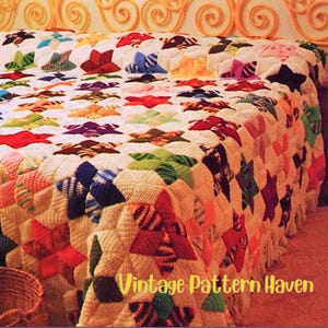 Puede incluir: Una colcha hecha a mano con un patrón de estrellas en varios colores, incluyendo rojo, azul, verde y morado, se muestra sobre una cama. La colcha tiene un fondo blanco y un borde con flecos. El texto "Vintage Pattern Haven" es visible.