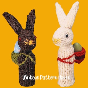 Könnte beinhalten: Zwei gestrickte Fingerpuppen in Form von Osterhasen. Ein Hase ist braun mit grünen und braunen Akzenten und trägt ein blaues und weißes Ei. Der andere Hase ist weiß mit roten und braunen Akzenten und trägt ein grünes Ei. Der Text "Vintage Pattern Haven" befindet sich am unteren Rand des Bildes.