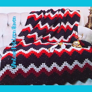 May include: A handmade crochet blanket with a chevron pattern in black, red, and white. The blanket is draped over a sofa, with a vintage telephone and lamp visible. The text "Vintage Pattern Haven" is on the left side.