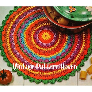 Puede incluir: Una alfombra redonda de crochet colorida con un centro multicolor y un borde verde. La alfombra tiene un borde festoneado y está hecha con una variedad de puntadas. La alfombra está sobre un suelo de baldosas blancas. Vintage Pattern Haven está escrito en la alfombra.