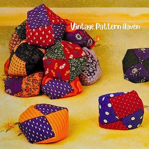 May include: A collection of fabric juggling balls, each constructed from multi-coloured patchwork panels featuring various floral, polka dot, and geometric patterns in shades of red, purple, orange, and green, with the text Vintage Pattern Haven.
