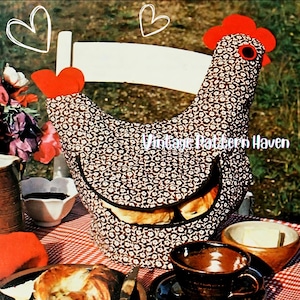 May include: A whimsical chicken-shaped bread warmer, featuring a brown and white floral pattern. The warmer has a red comb and wattle, and a black outline for the beak. The text "Vintage Pattern Haven" is visible on the warmer.