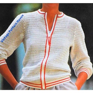May include: White crochet cardigan with a red zipper and red trim. The cardigan has a mesh pattern.