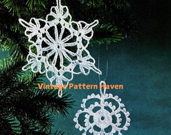 May include: Two white crocheted snowflakes hanging from a pine tree branch against a teal background. The larger snowflake has six points and the smaller snowflake has five points. The text "Vintage Pattern Haven" is visible in the lower center of the image.