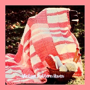 May include: A handmade crochet blanket in shades of pink and white, draped over a wooden bench. The blanket features a checkered pattern. A basket holds yarn, knitting needles, and other supplies. The text "Vintage Pattern Haven" is visible.