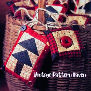 May include: Two handmade, quilted ornaments with red and black plaid and triangle patterns. One features a tree design, the other a large red button. The ornaments are attached to a basket with twine. The text "Vintage Pattern Haven" is visible.