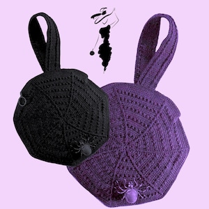 May include: Two crocheted handbags, one black and one purple, each featuring a spiderweb design and a spider embellishment. The bags have a rounded shape with a handle. The background is a light purple.