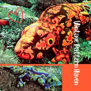 May include: Two plush lizard-shaped pillows. The top pillow has a black, orange, and yellow patterned design. The bottom pillow has a blue, green, and purple patterned design. The image has the text "Vintage Pattern Haven".