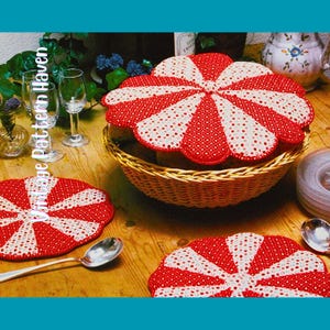 Op de afbeelding: Een rieten mand met een rood-wit patroon, samen met twee bijpassende onderzetters en een lepel, staat op een houten tafel. De deksel en onderzetters hebben een geschulpte rand. De tekst "Vintage Pattern Haven" is zichtbaar.