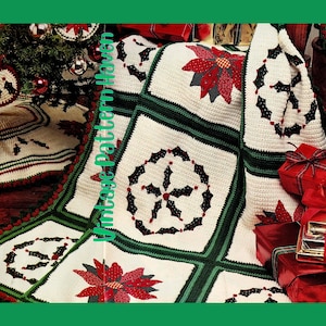 May include: A handmade Christmas afghan with a white background, green borders, and red and black holly and poinsettia designs. The afghan is folded over a Christmas tree and presents.