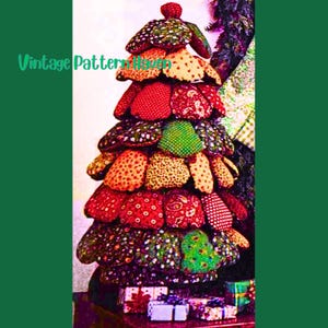 Peut inclure: Un sapin de Noël fait à la main avec des patchs de tissu colorés. Le sapin est orné de tissus rouges, verts, jaunes et à motifs. Le texte "Vintage Pattern Haven" est visible sur le côté gauche de l'image.