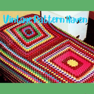 May include: A colorful, crocheted blanket with a square pattern. The blanket features a variety of colors, including red, pink, green, yellow, and blue. The text "Vintage Pattern Haven" is displayed in the image.