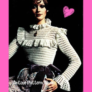 May include: A white long-sleeved crochet top featuring a high ruffled collar, ruffled shoulders, and a textured openwork pattern. The garment is paired with a dark purple velvet ribbon tied at the waist and a patterned skirt with the text Vintage Pattern.