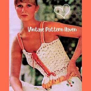 May include: Cream-colored crochet top with orange and white trim and straps. The top has a lace-up detail on the front and a ruffled hem. The text "Vintage Pattern Haven" is displayed across the top of the image.