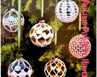 May include: Six crocheted Christmas ornaments hanging on a green Christmas tree. The ornaments are made with white and pink yarn and are in the shape of a sphere. The ornaments are decorated with a variety of patterns. The ornaments are hanging from green ribbon.