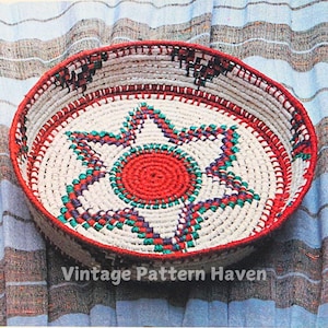 May include: A woven basket with a red, white, green, and purple star design. The basket is round and has a white background.