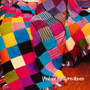 May include: A colorful, handmade patchwork blanket with a variety of textures and patterns. The blanket features squares of vibrant colors including pink, blue, yellow, orange, and black. The text "Vintage Pattern Haven" is visible on the blanket.
