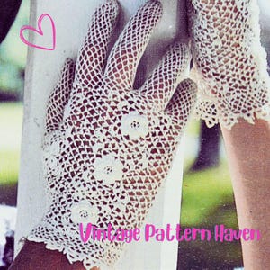 Op de afbeelding: Crèmekleurige, open geweven gehaakte handschoenen met bloemaccenten. De handschoenen hebben een delicaat, kantachtig ontwerp en zijn versierd met kleine, driedimensionale bloemen. De tekst "Vintage Pattern Haven" is zichtbaar.